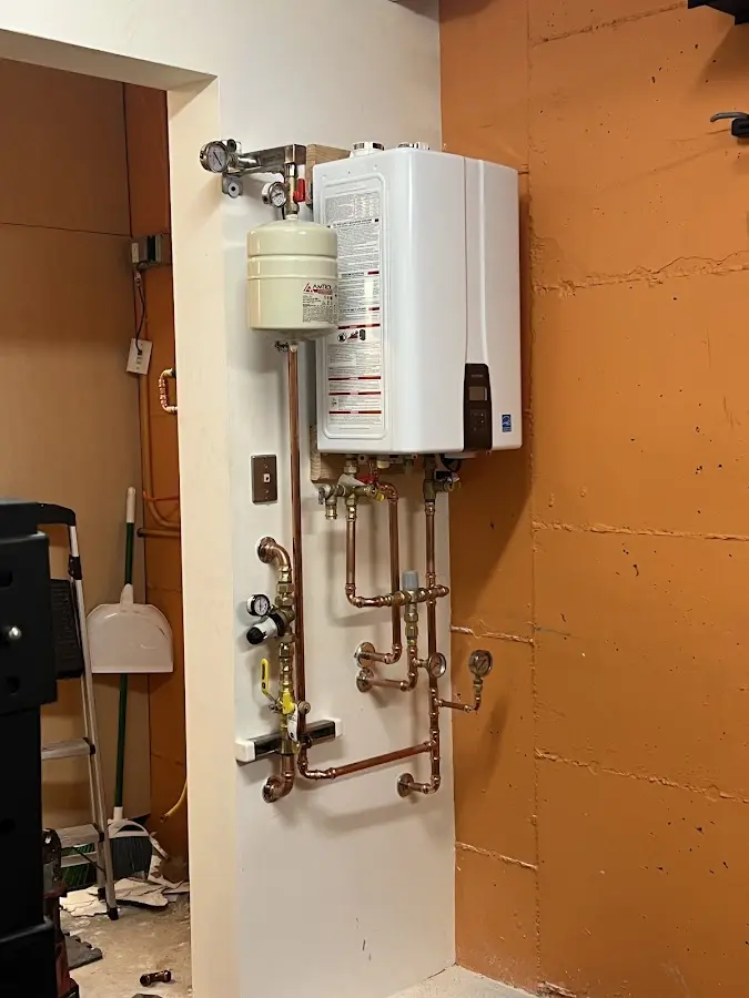Plumbing technician inspecting water heater connections in Eden